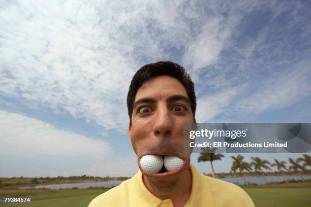 hispanic man with golf balls in mouth - golf humor stock pictures, royalty-free photos & images