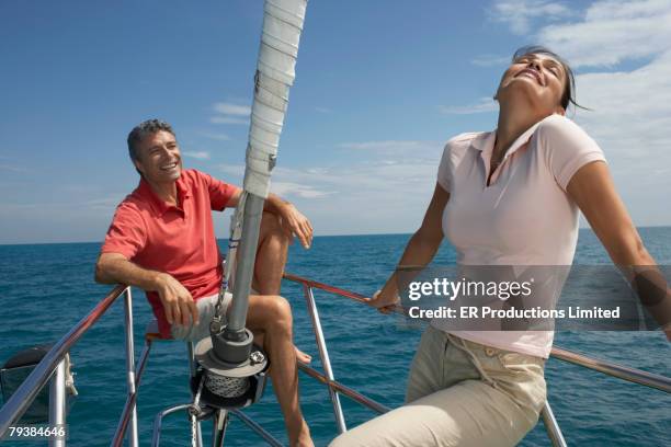 multi-ethnic couple on bow of sailboat - yachting stock pictures, royalty-free photos & images
