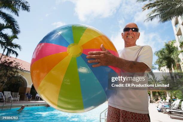 senior man holding beach ball - man with big balls stock pictures, royalty-free photos & images