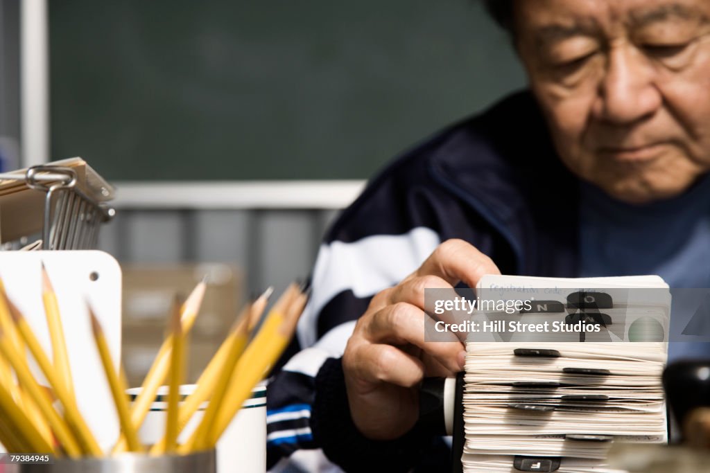 Senior Asian man looking at circular card file