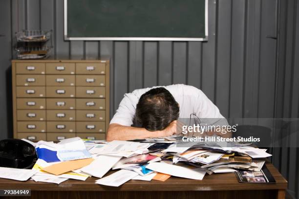 senior asian businessman resting head on cluttered desk - overdoing stock pictures, royalty-free photos & images