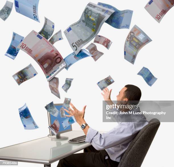 money flying out of asian man's computer - european union euro note stock pictures, royalty-free photos & images