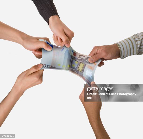 group of businesspeople pulling on money - money challenge stock pictures, royalty-free photos & images