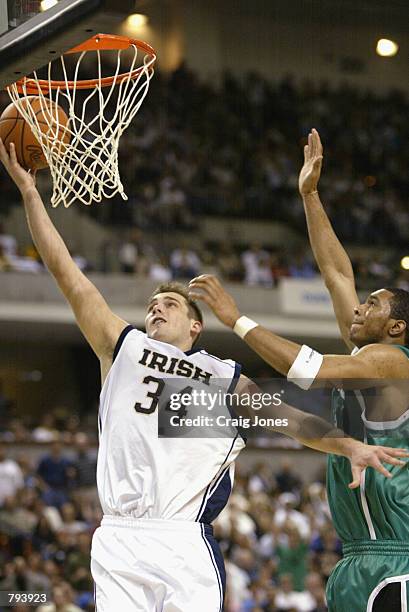 David Graves of the Notre Dame Fighting Irish leaps to make a basket as he is guarded by Eddie Basden of the UNC Charlotte 49ers during the first...