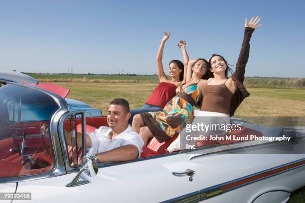 hispanic man with three women in convertible - low rider stock pictures, royalty-free photos & images