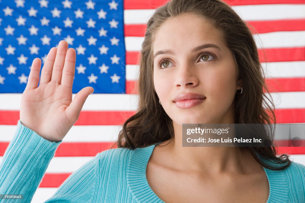 Hispanic teenaged girl in front of American flag