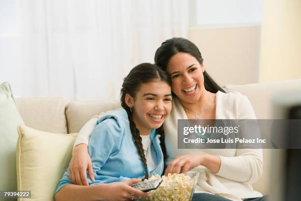 hispanic mother and daughter watching movie - teenagers eating with mum stock pictures, royalty-free photos & images