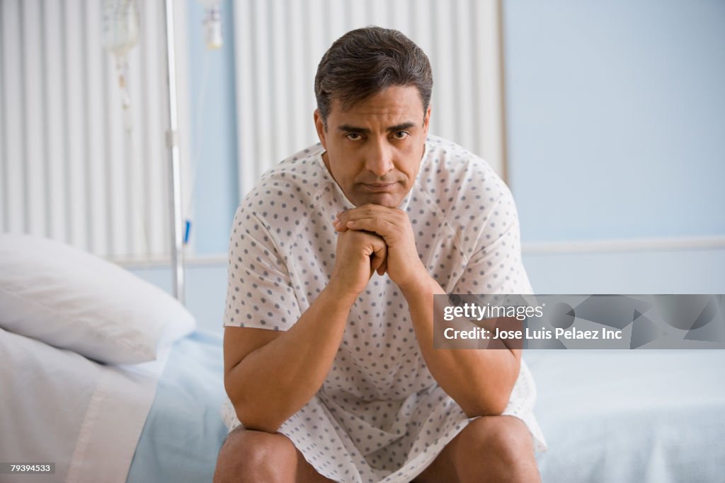 Hispanic man wearing hospital gown