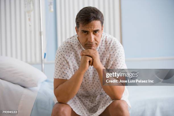 hispanic man wearing hospital gown - hospital gown imagens e fotografias de stock