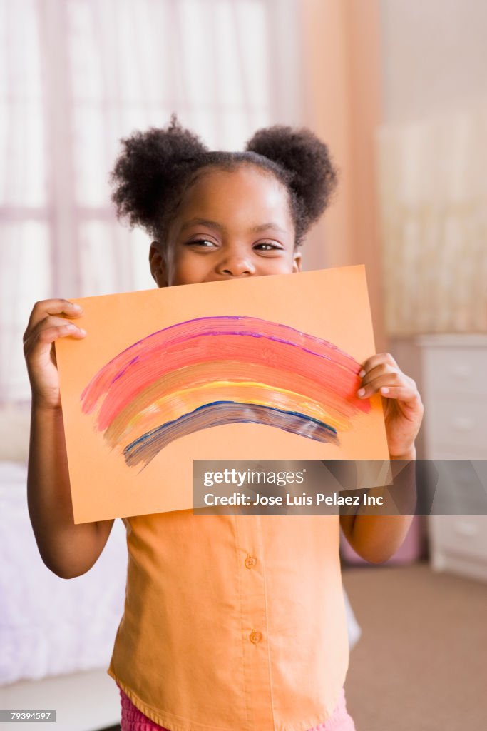 African American girl holding up painting