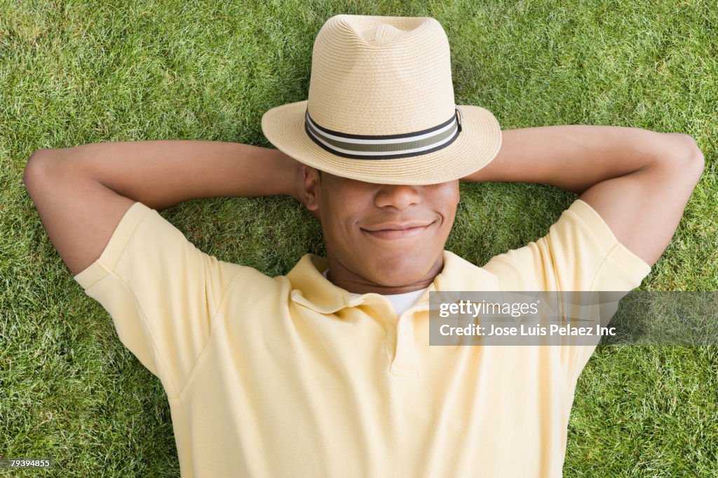 Mixed Race man laying in grass