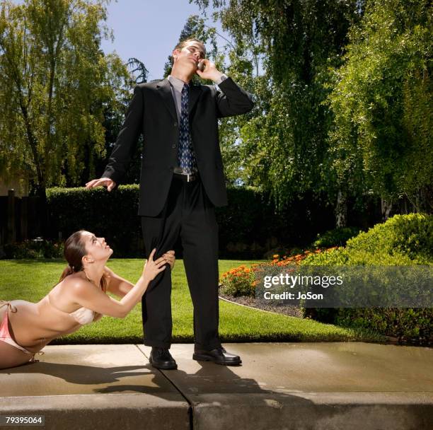 hispanic woman in bikini grabbing businessman's leg - joined at hip stock pictures, royalty-free photos & images