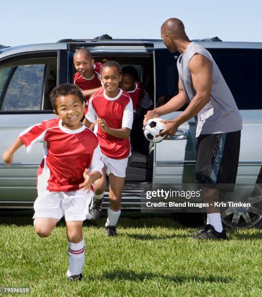 multi-ethnic children in soccer uniforms - carro de corrida fotografías e imágenes de stock
