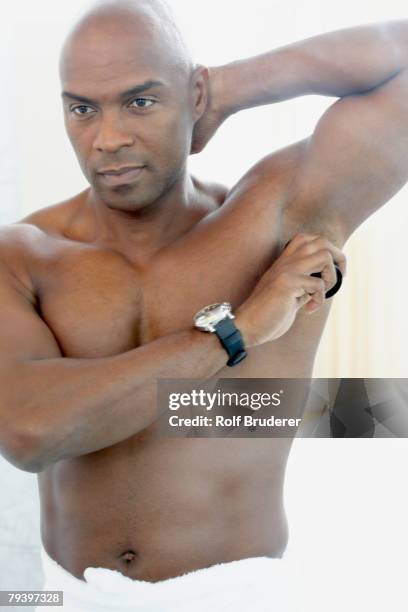 african american man putting on deodorant - man deodorant stock pictures, royalty-free photos & images