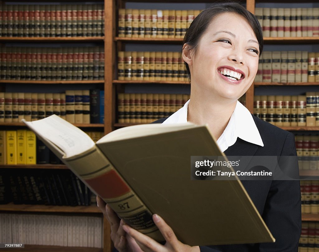 Asian woman holding library reference book