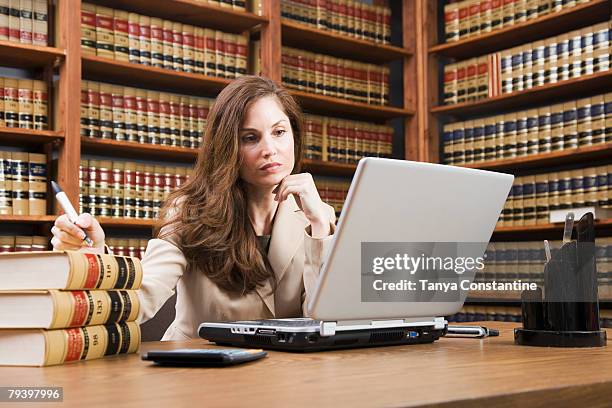 hispanic woman looking at laptop - studio legale foto e immagini stock