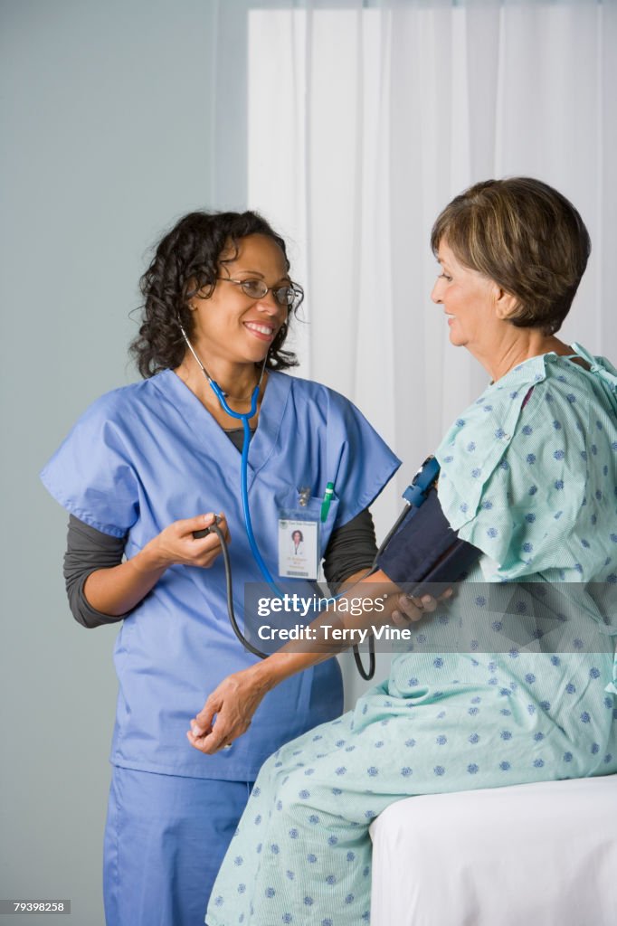 African American nurse taking patient's blood pressure