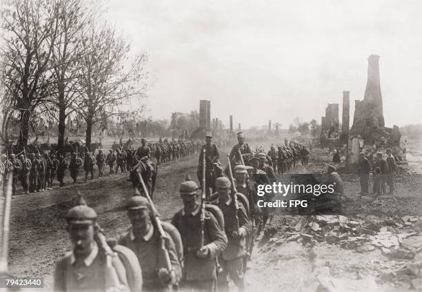 German troops advance past the town of Puchaczow in East Prussia , burnt down by retreating Russian forces on the Eastern Front during World War I,...