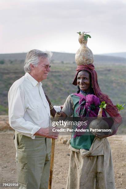 Austrian actor KarlHeinz Bohm meets a woman as he visits an opening of a water project for several villages in a rural area February 7, 2001 outside...
