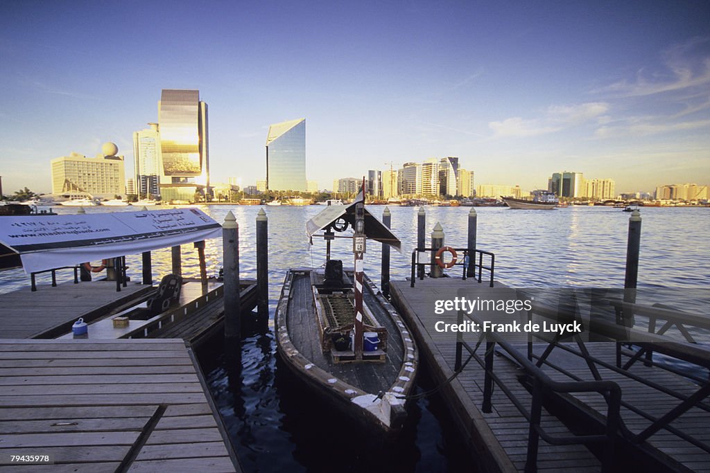 Dubai skyline with an abra docked in Dubai Creek in the foreground. Dubai, United Arab Emirates
