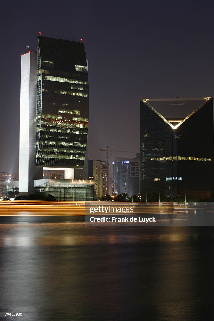 Abras and Dhows passsing the National Bank of Dubai at Dubai Creek during twilight. Dubai Creek, Dubai, United Arab Emirates