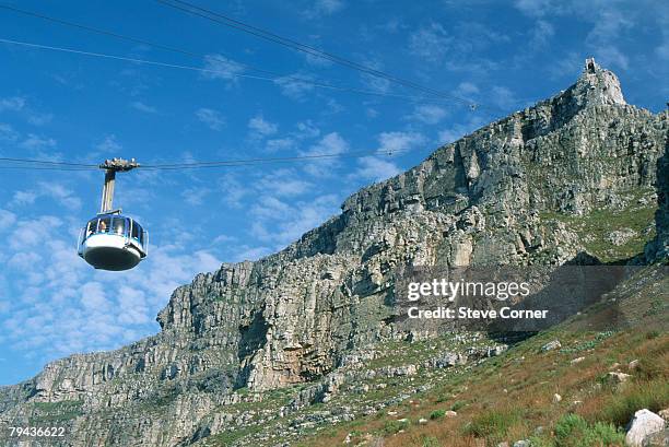 low angle view of a cable car ascending table mountain. cape town, western cape province, south africa - cape town cable car stock pictures, royalty-free photos & images