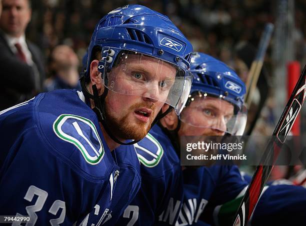 Henrik Sedin and Daniel Sedin of the Vancouver Canucks look on from their bench during their game against the Dallas Stars at General Motors Place on...