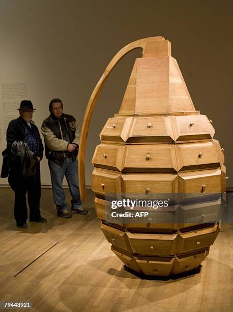 Visitors stand before a piece titled Estuche by Los Carpinteros, Alexandre Arrechea, Marco Castillo and Dagoberto Rodriguez during "The Cuba Art and...