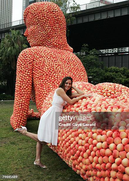 Actress Jolene Anderson poses next to a 12 metre high sculpture which was modelled on her and made from peaches in Fleet Park on February 1, 2008 in...