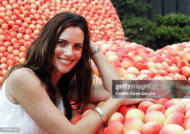 Actress Jolene Anderson poses next to a 12 metre high sculpture which was modelled on her and made from peaches in Fleet Park on February 1, 2008 in...