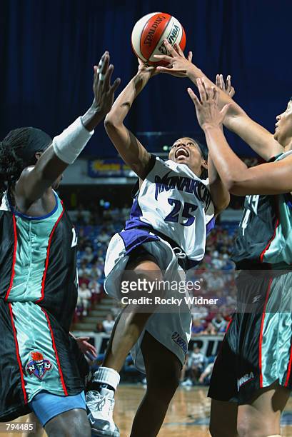 Kedra Holland-Corn of the Sacramento Monarchs puts a shot up over Tamika Whitmore and Tari Phillips of the New York Liberty during the game at Arco...