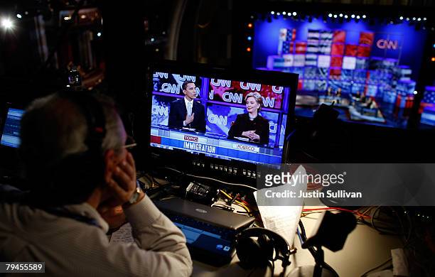 Radio reporter watches a televised broadcast of democratic presidential hopefuls US Sen. Barack Obama and US Sen. Hillary Clinton as they participate...