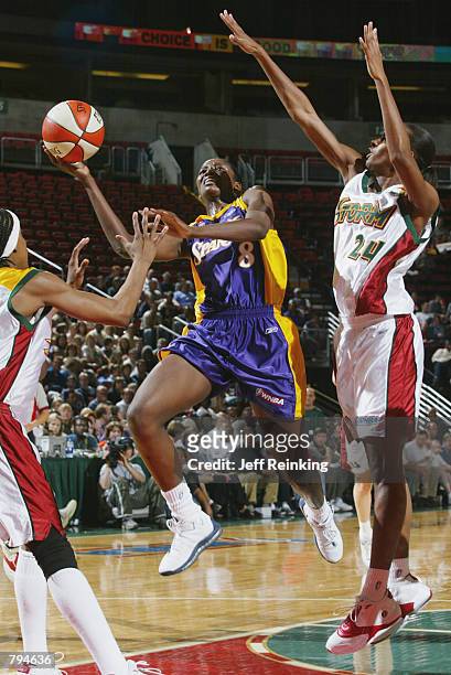 DeLisha Milton of the Los Angeles Sparks shoots past Amanda Lassiter and Felicia Ragland of the Seattle Storm during the game on June 18, 2002 at Key...