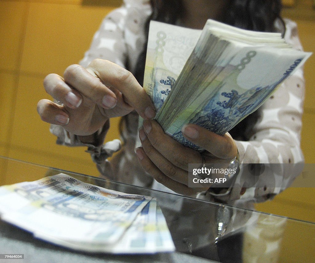 A teller shows thousand peso bills insid