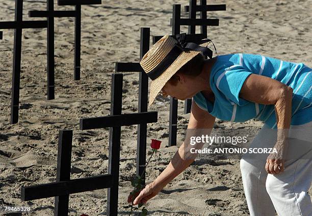 Woman lays a rose on February 1, 2008 next to one of the crosses representing the 586 police agents killed on duty last year, on Copacabana beach in...