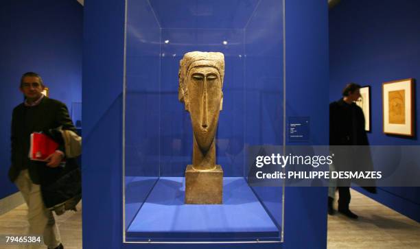 Visitor passes by 'Head', a sculpture by Italian painter Amedeo Modigliani at the opening of an exhibition "Modigliani and his times" at the...