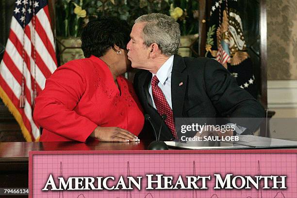 President George W. Bush kisses heart disease survivor Joyce Cullen after signing a Presidential Proclamation in honor of American Heart Month at the...