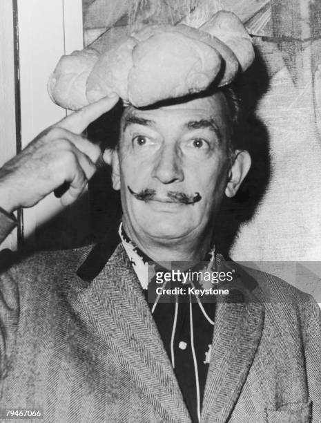 Spanish surrealist artist Salvador Dali wears a hat shaped like a loaf of bread on his head, 5th November 1958.