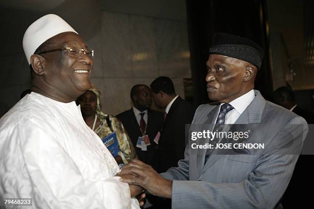 The chairman of the African Union Commission, Alpha Omar Konare, talks to the Senegalese President Abdoulaye Wade during the 10th African Union...