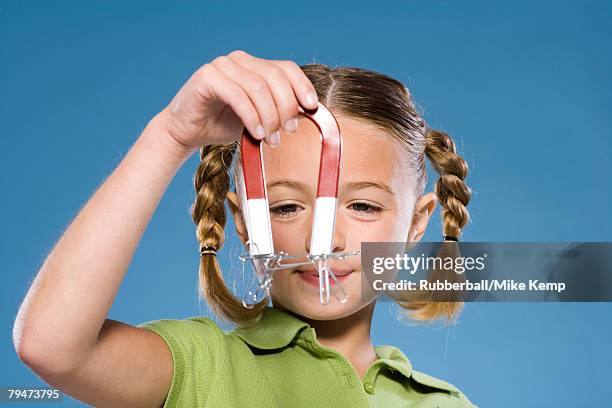 child holding a magnet - hoefijzermagneet stockfoto's en -beelden