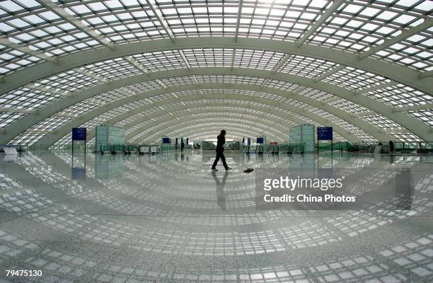 Worker cleans the floor in the Ground Transportation Center , connecting the Beijing airport light rail line, in the new terminal building T3 at the...