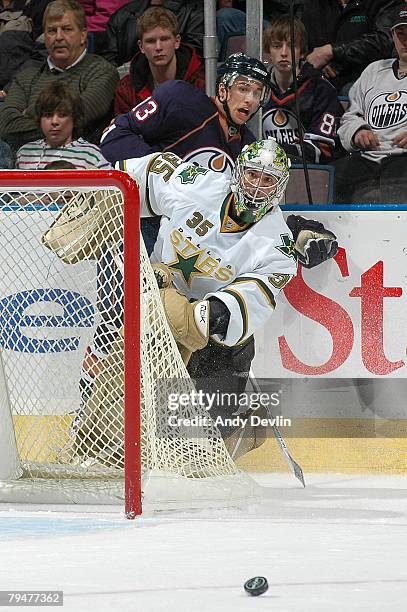 Marty Turco of the Dallas Stars plays the puck while being pressured by Andrew Cogliano of the Edmonton Oilers at Rexall Place February 1, 2008 in...