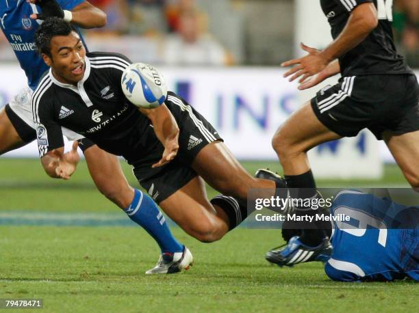 Victor Vito of New Zealand makes a pass as he gets tackled by Reupena Levasa of Samoa during the Cup final match between Samoa and New Zealand during...