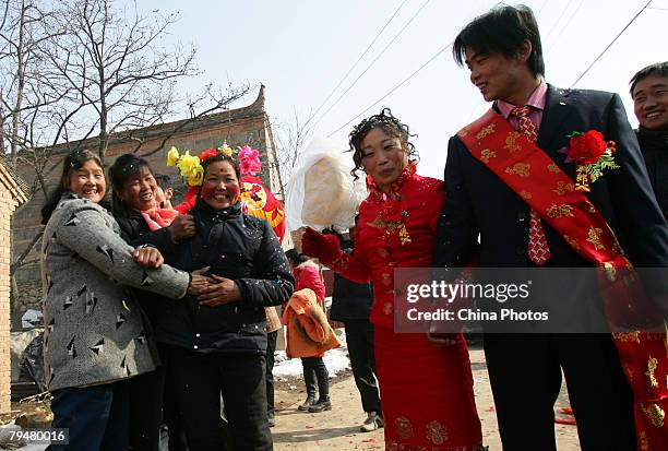 The mother of groom wearing flowers to receive groom and bride during a rural wedding ceremony on February 2, 2008 in the outskirts of Xian of...
