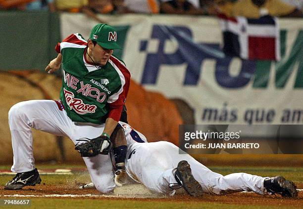 Agustin Murillo of Yaquis of Mexico tags out Miquel Tejada of Aguilas del Cibao of the Dominican Republic as he slides into third base during their...