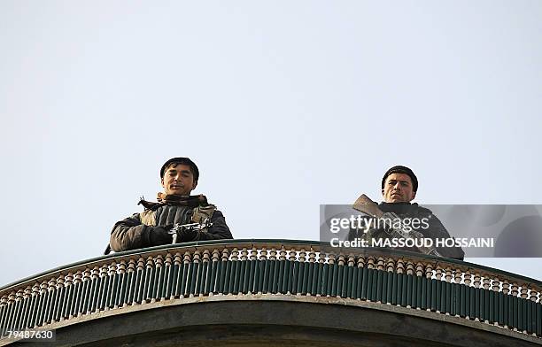 Afghan policemen stand guard on a roof near the house of notorious Afghan warlord General Abdul Rashid Dostum in Kabul which was surrounded by more...