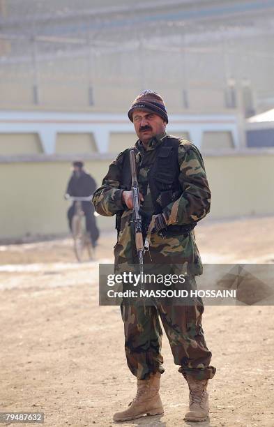 An Afghan security man of notorious Afghan warlord General Abdul Rashid Dostum stands guard near his house in Kabul which was surrounded by more than...