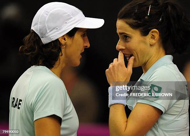 French tennis doubles pair Virginie Razzano and Nathalie Dechy confer during their match against Chinese opponents Zheng Jie and Yan Zi during a...