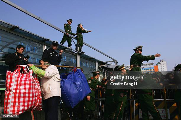 An officer advises passengers stranded due to heavy snow in the Guangzhou Railway Station on February 3, 2008 in Guangzhou of Guangdong Province,...