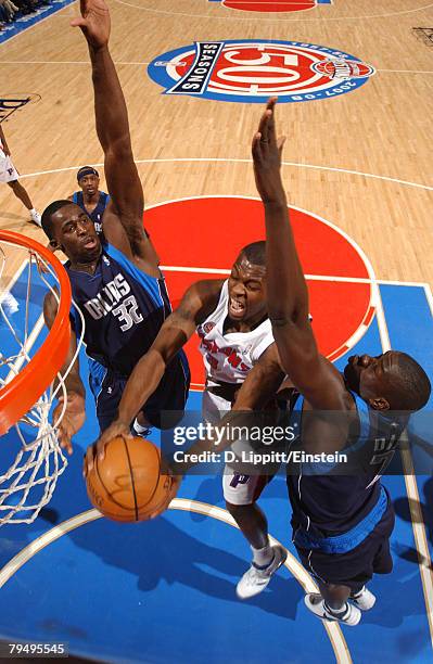 Rodney Stuckey of the Detroit Pistons tries to get a shot off tightly defended by Brandon Bass and DeSagana Diop of the Dallas Mavericks on February...